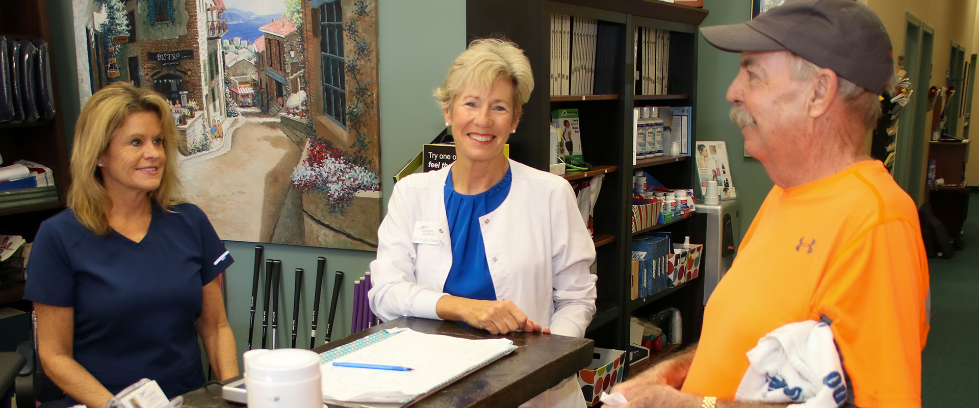 Dr. Vivian Ebert with nurse and patient at front desk